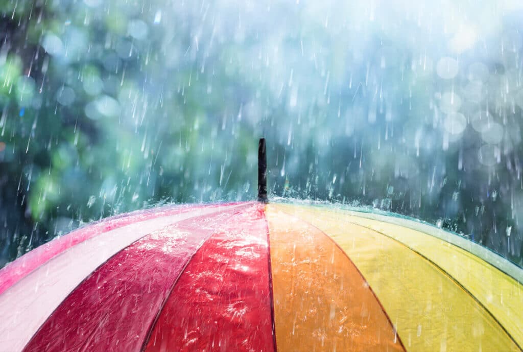 rain falling on rainbow umbrella