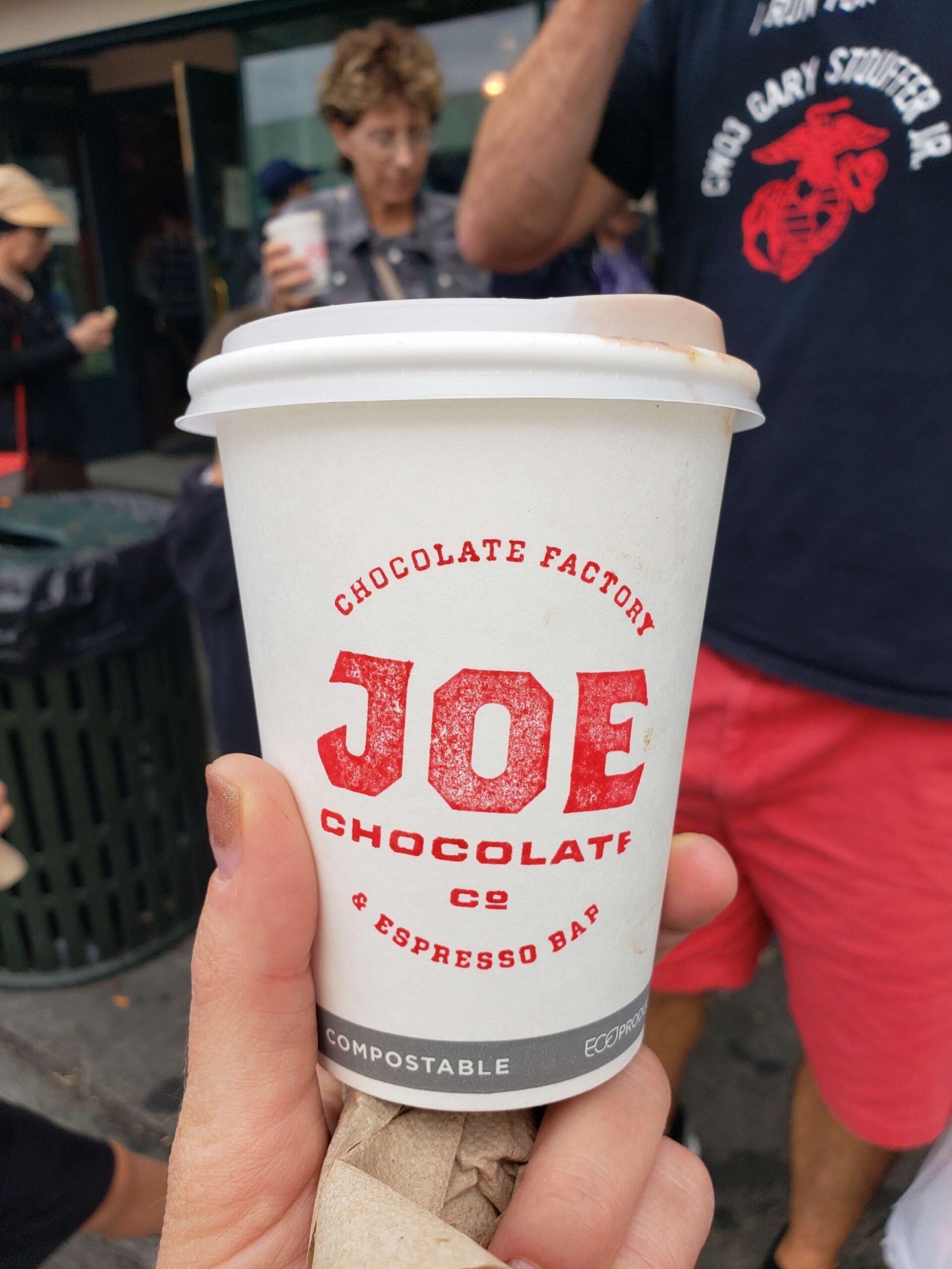 Hand holding a Joe Chocolate Co. coffee cup at Pike Place Market