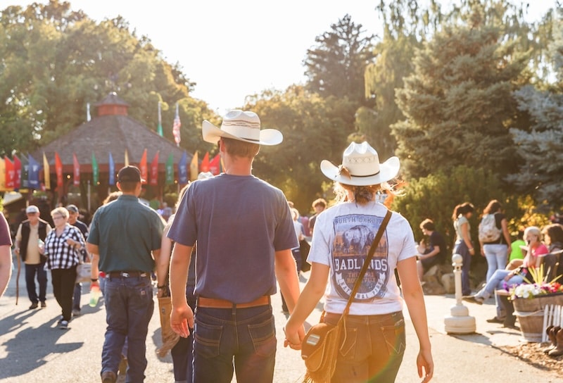 Couple holding hands walking into the Kittitas County Fair 