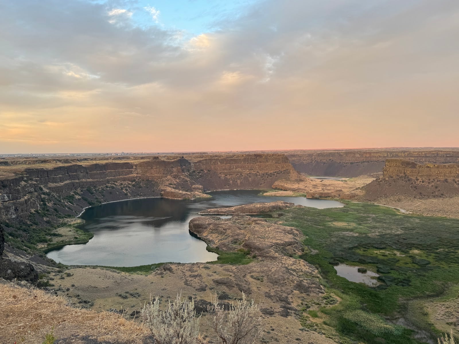 Dry Falls cliffs and lakes in the Grand Coulee under a sunset sky