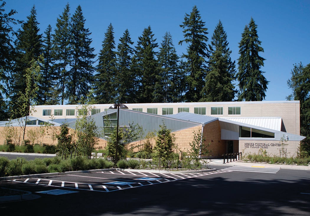 The Hibulb Cultural Center building among tall evergreens in Tulalip