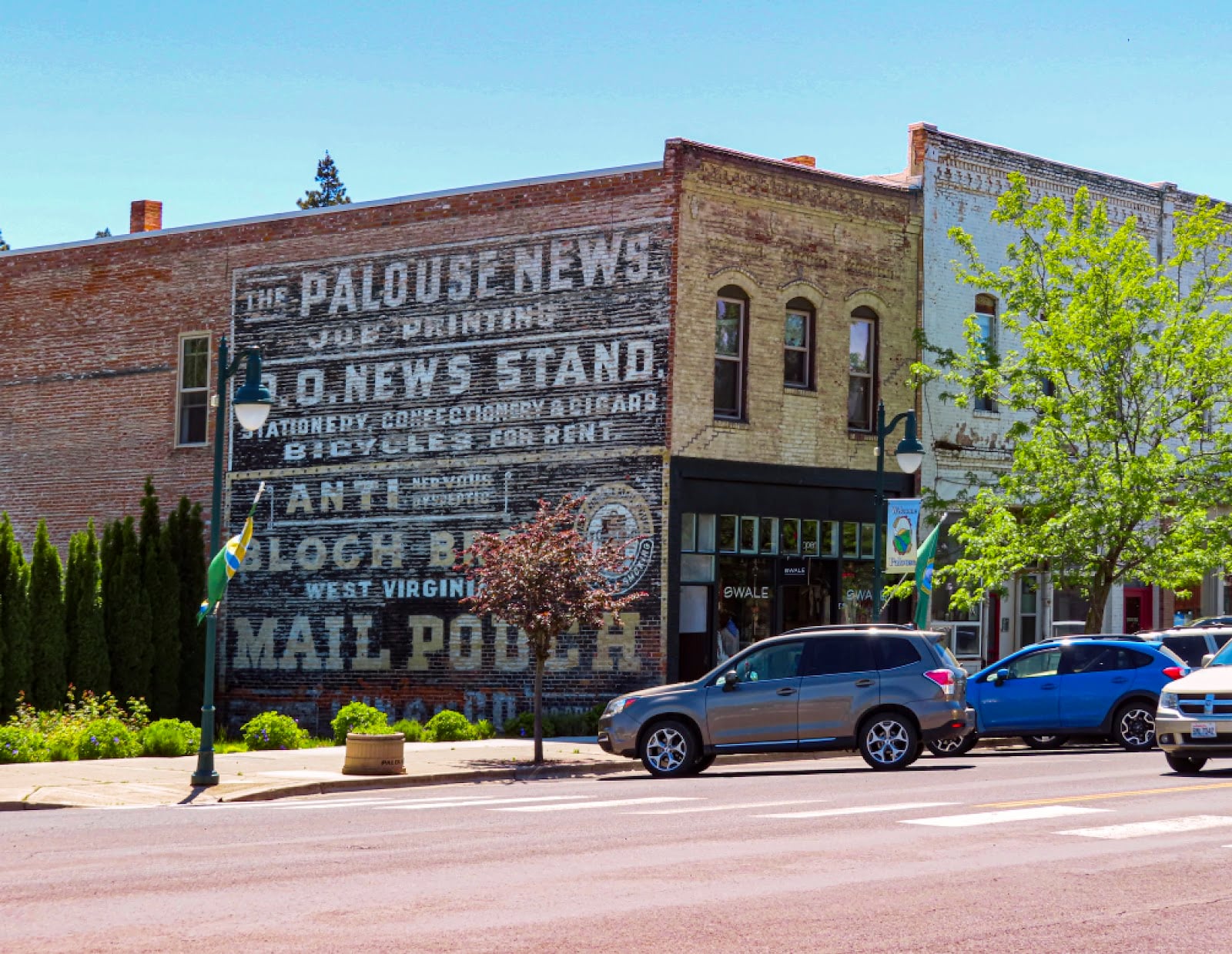 Painted Palouse News and Mail Pouch signs on a brick building on Main Street in Palouse