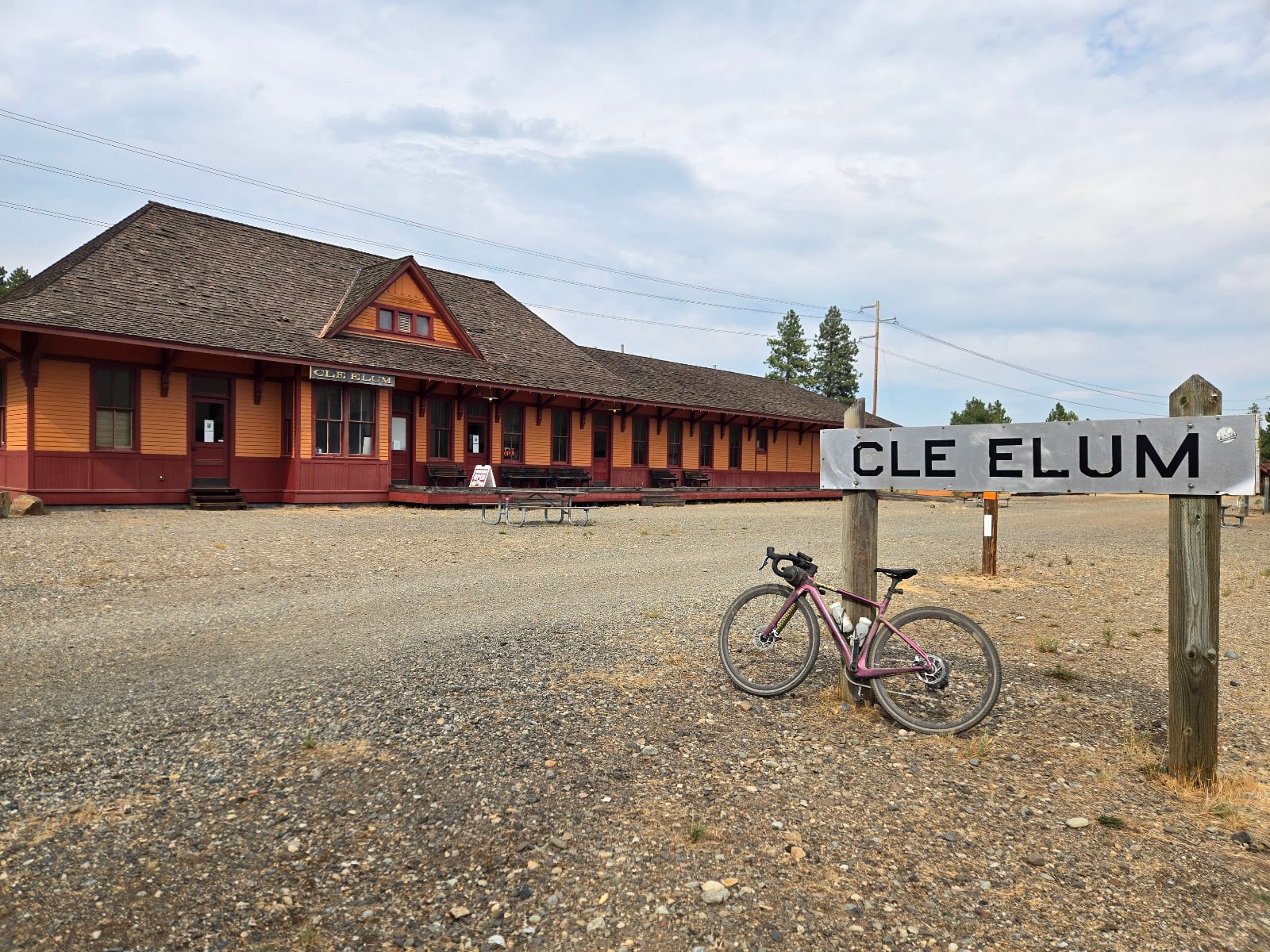 The South Cle Elum Depot, a long red railroad building, behind a Cle Elum station sign