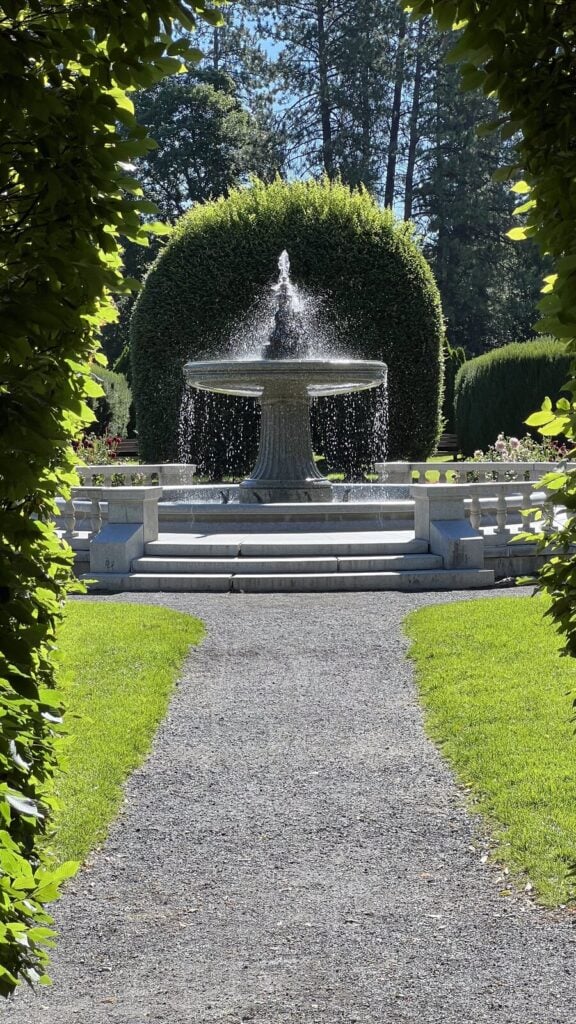 Clipped hedge tunnel framing the Duncan Garden fountain at Manito Park in Spokane