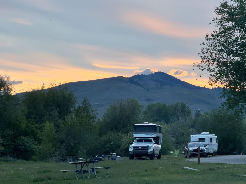 Campers and picnic tables at Pearrygin Lake State Park under a pink evening sky