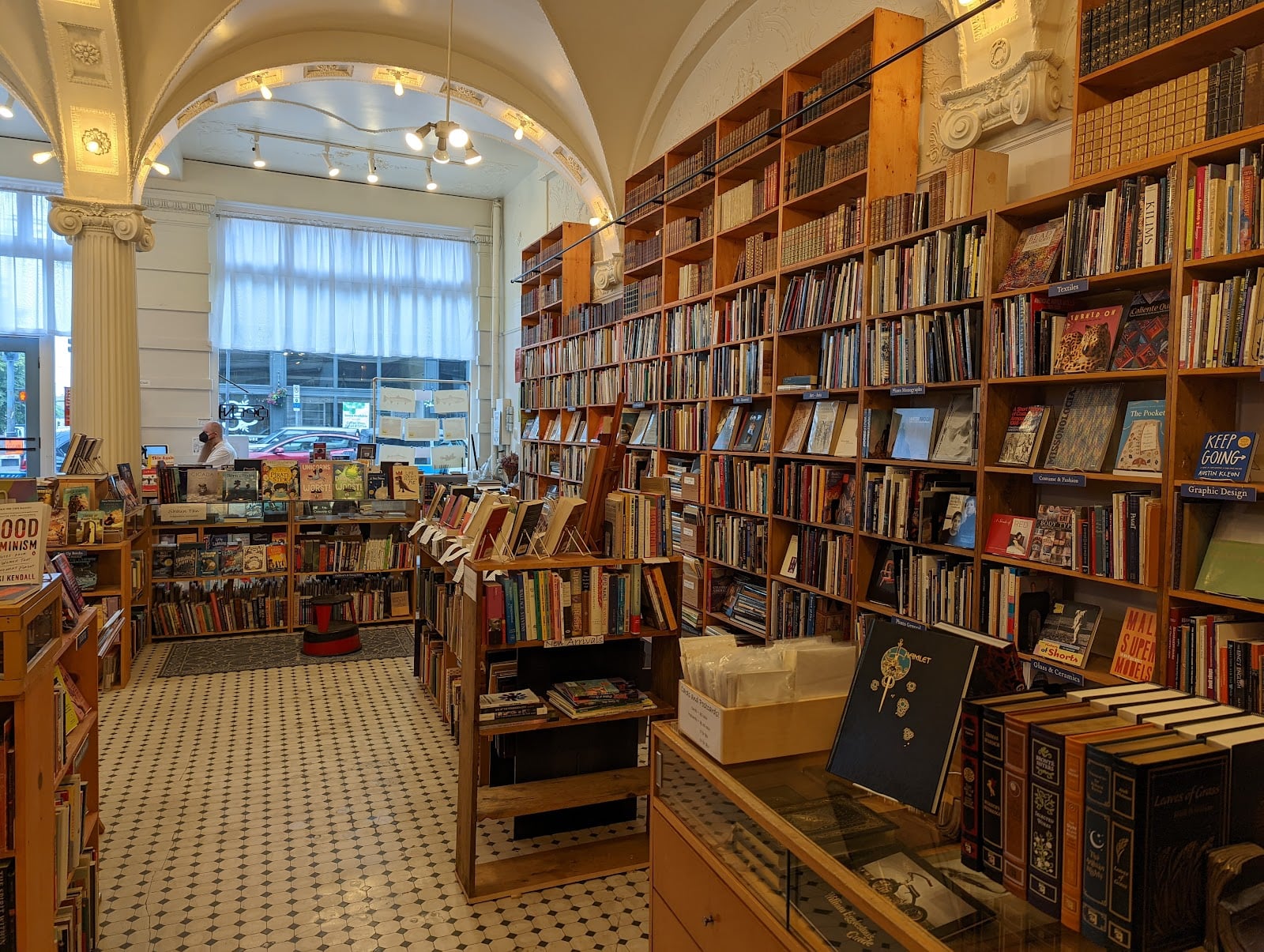 Tall wooden bookshelves under an arched white ceiling inside Arundel Books in Pioneer Square