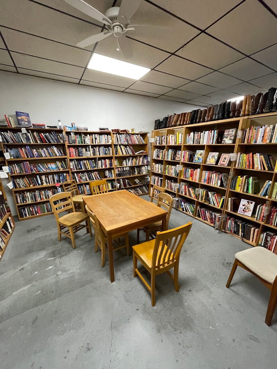 Reading tables and chairs among tall wooden bookshelves at King's Books