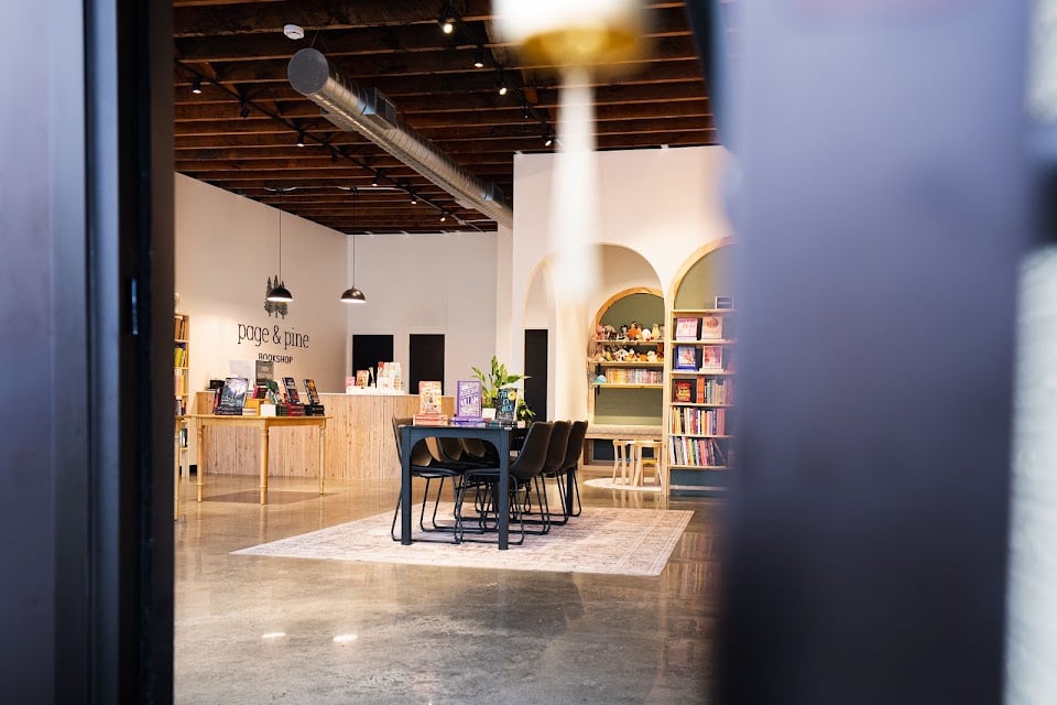The arched shelves and reading table of Page and Pine Bookshop, seen through the front door